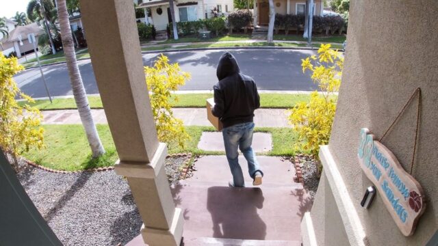 man taking a package captured on a video doorbell